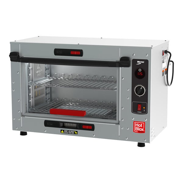 A silver and black Metro HotBlox Xpress small countertop heated holding cabinet with a rack of food inside.