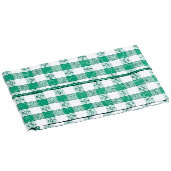 A folded green and white gingham vinyl table cover with a flannel back.