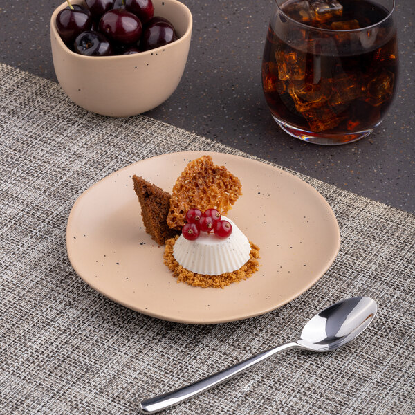 A brown Ariane Earth porcelain plate with dessert and red berries.