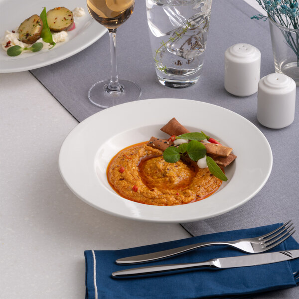 A round, wide rim deep white porcelain plate with food served on it.