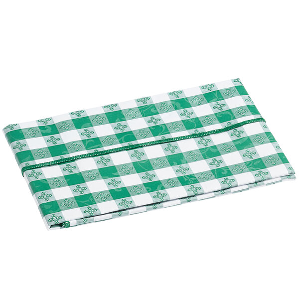 A folded green and white gingham vinyl table cover with a flannel back.