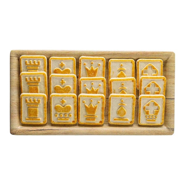 A rectangular faux wood melamine serving tray holding cookies shaped like chess pieces.