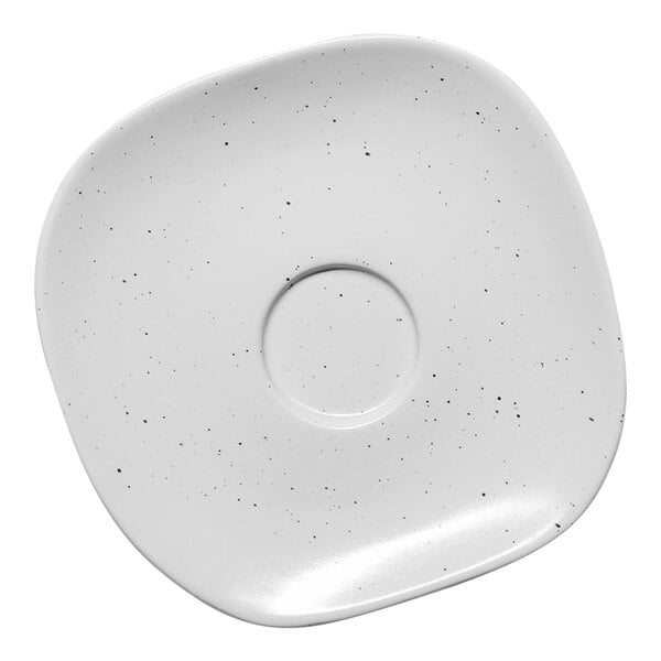 A white porcelain saucer with linen dots.