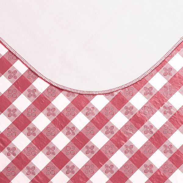 A burgundy and white gingham vinyl table cover with a flannel back.