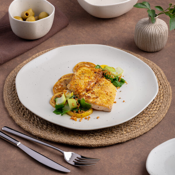 An Ariane Earth porcelain plate with food on a table.
