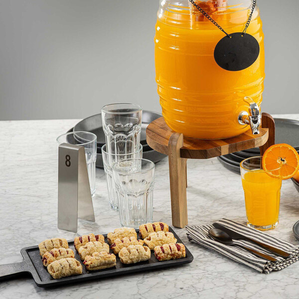 A rectangular black faux wood melamine serving tray with a 4 1/2 inch handle, displayed with pastries on a marble table.
