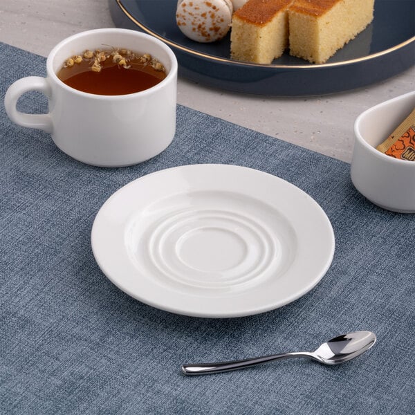 A round, warm white porcelain mug saucer with a wide rim.