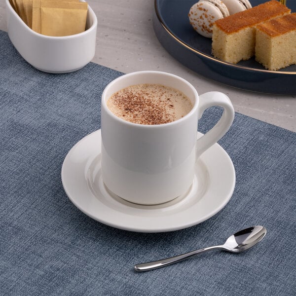 A white porcelain coffee cup with a handle, placed on a matching saucer.