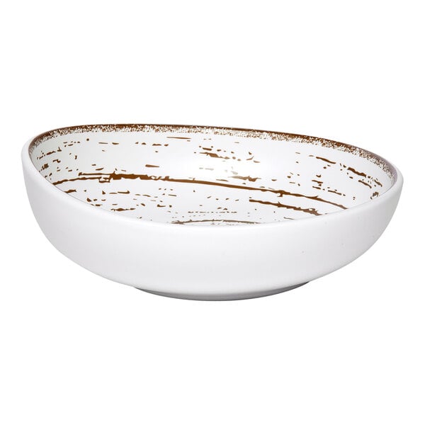 An Ariane white porcelain slanted coupe bowl with brown specks.