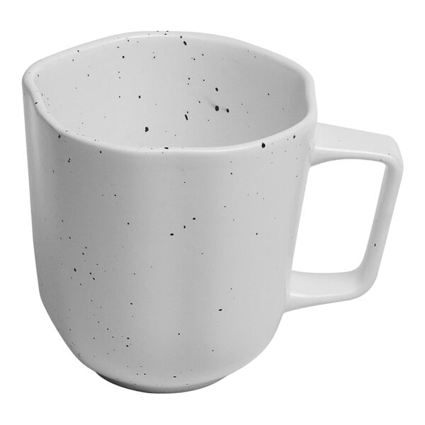 A white porcelain mug with black specks.