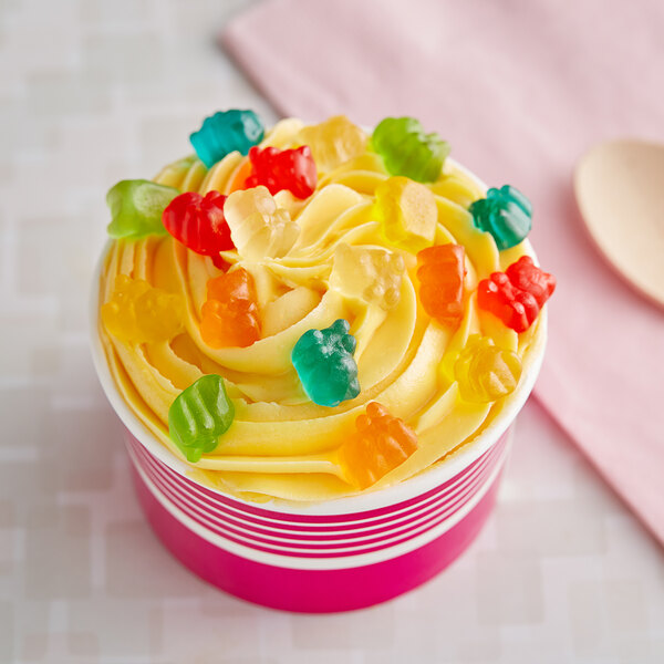 A cupcake with yellow frosting and Kervan Mini Gummy Bears on top.