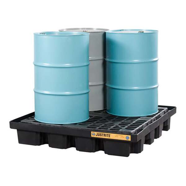 A black plastic pallet holding three large industrial drums, designed for spill containment.