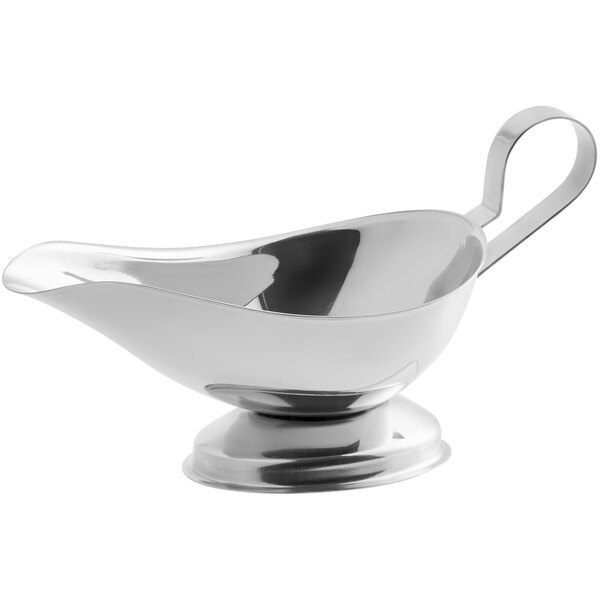 A stainless steel gravy boat with a handle and pedestal base.