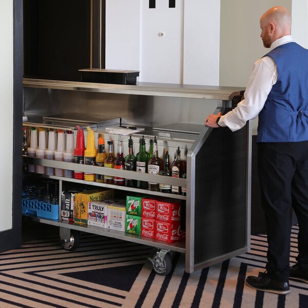 A large black laminate and stainless steel electric portable bar with a fixed speed rail, two 40 lb. ice bins, and various beverage supplies.