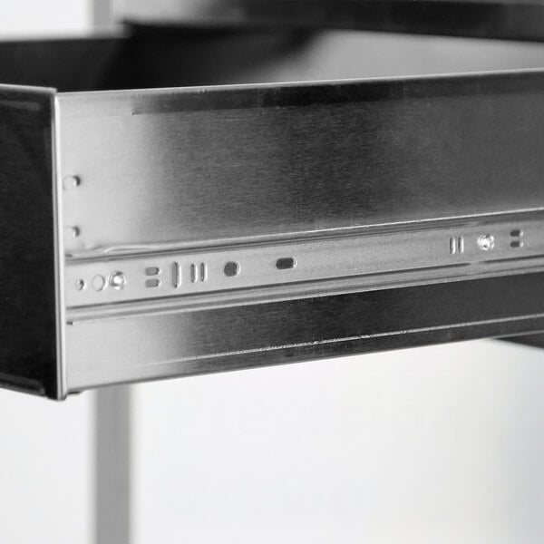 A close-up view of a stainless steel drawer on an equipment stand.