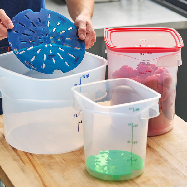 A translucent round polypropylene food storage container with measurement markings and a colored insert, shown alongside other similar containers.