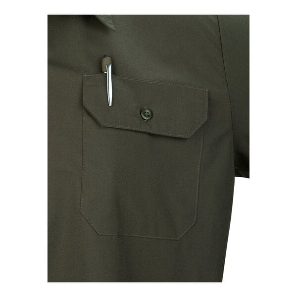 A close-up of an olive green short sleeve work shirt with a buttoned chest pocket holding a pen.