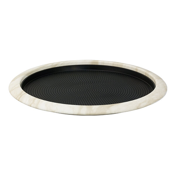 A round white marble serving tray with a removable black non-slip insert.