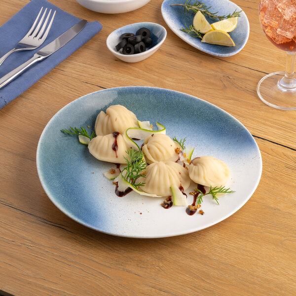 A blue and white ombre slanted porcelain flat coupe plate with food served on it.