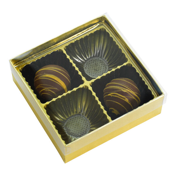 A gold 4-cavity candy box with a transparent lid, containing two chocolate candies.