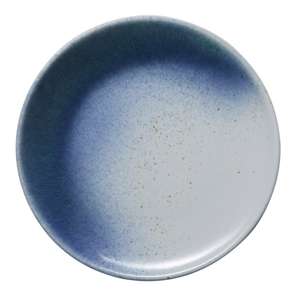 A round porcelain plate with a blue and white ombre design and subtle speckled accents.