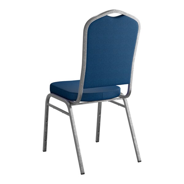 A stackable banquet chair with a navy fabric seat and backrest and a silver vein metal frame.