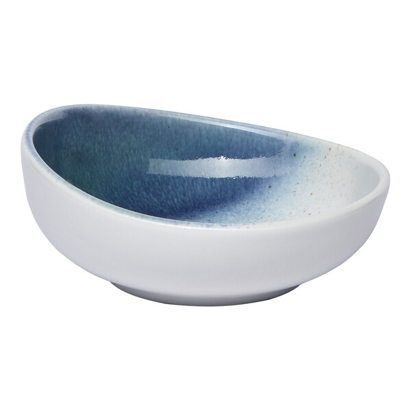 A small round porcelain coupe bowl with a blue and white ombre design.
