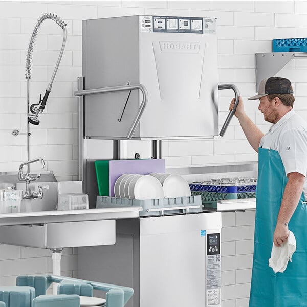 A commercial high temperature door-style tall base electric dishwasher with a booster heater in a kitchen setting.