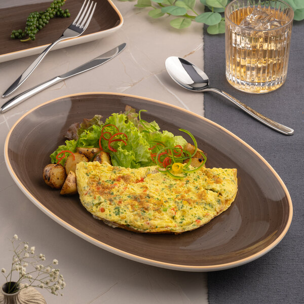 An oval porcelain plate with a brown interior and beige rim, shown holding an omelette, potatoes, and salad.