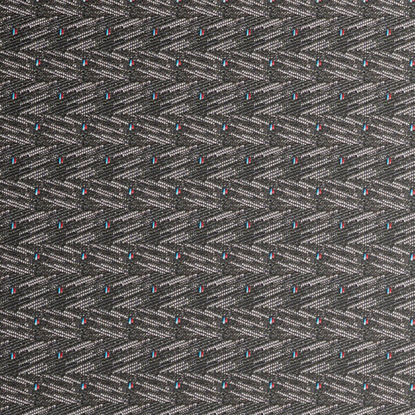 A close-up view of a black patterned fabric with a geometric design, used for a stackable banquet chair.