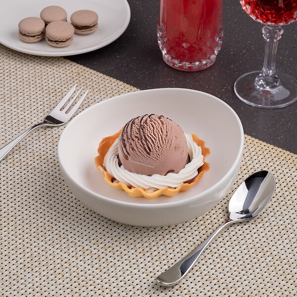 A large, round, slanted warm white porcelain coupe bowl.