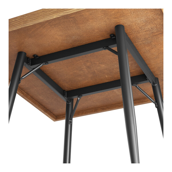A black metal bar height table base attached to a square wooden tabletop.