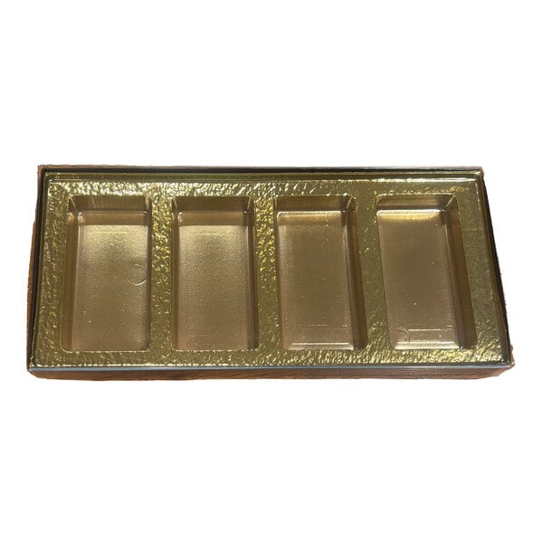 A rectangular black and gold candy box with four cavities and a transparent lid.