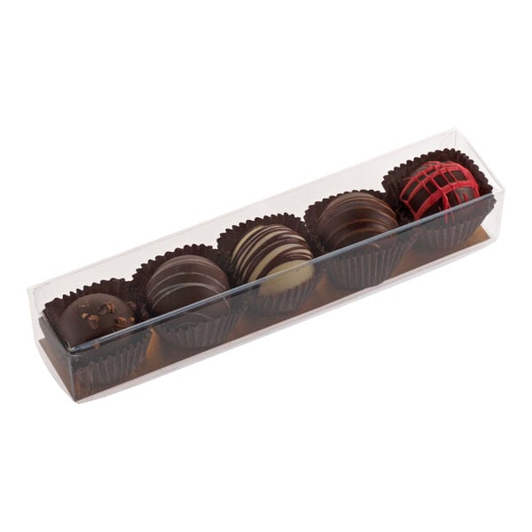 A transparent rectangular candy box containing five assorted chocolate truffles.