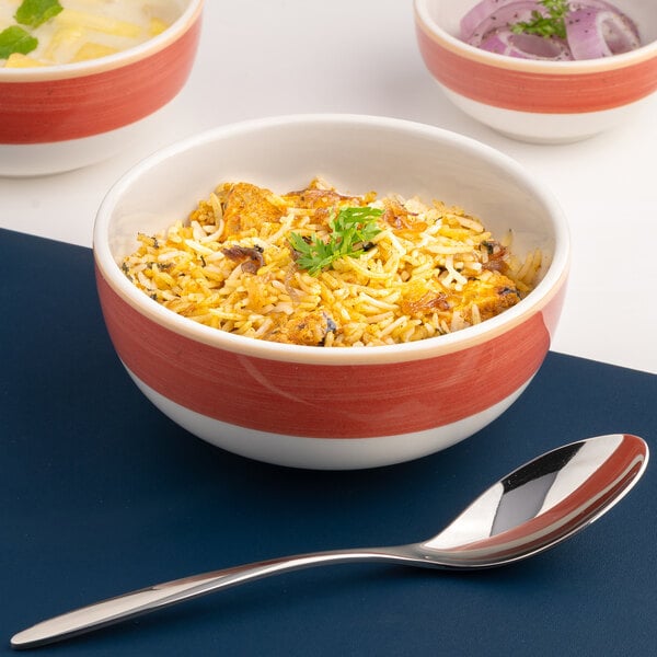 A red and white two-tone round porcelain bowl filled with food.