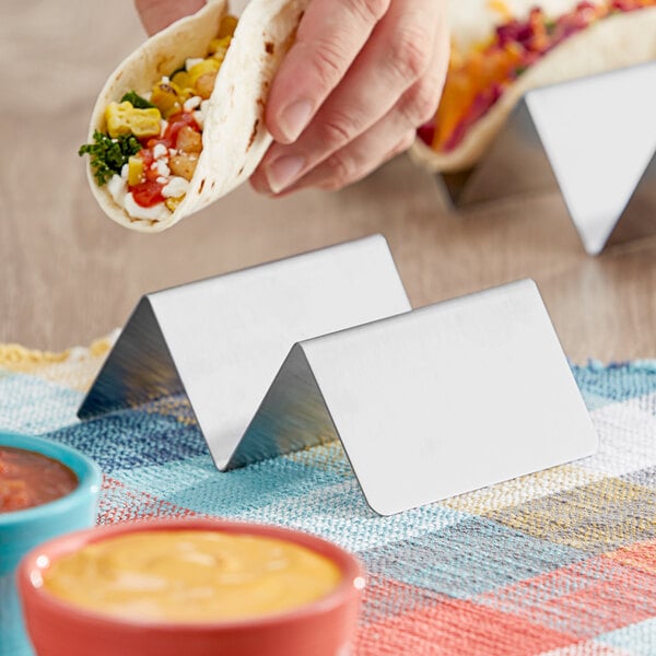 A stainless steel taco holder with two compartments for holding tacos upright.