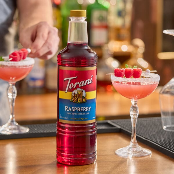 A 1-liter plastic bottle of Torani Raspberry flavoring and fruit syrup.