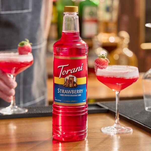 A 1-liter plastic bottle of Torani Strawberry flavoring syrup.