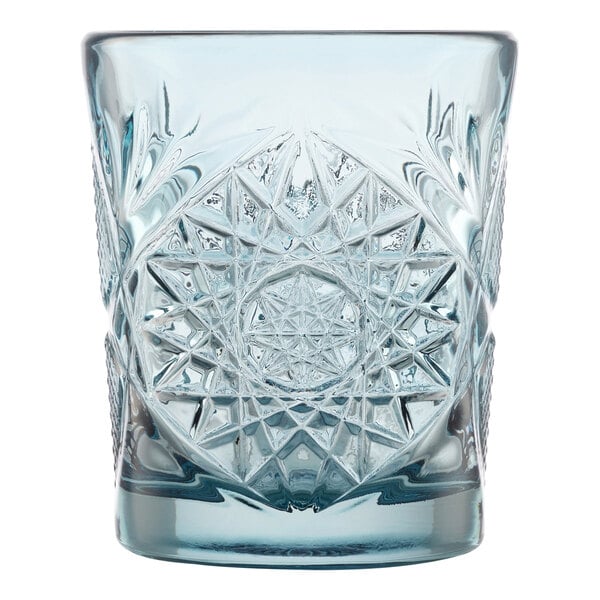 A blue glass tumbler with an intricate starburst pattern.