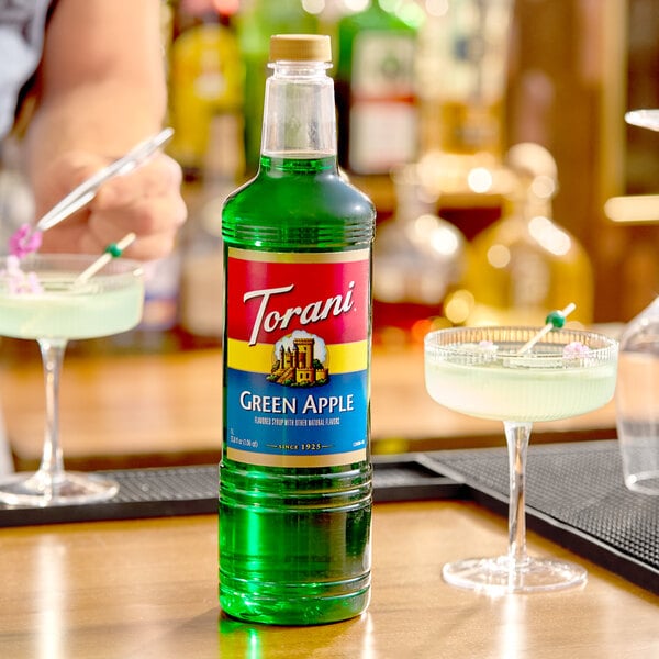 A 1-liter plastic bottle of Torani Green Apple flavoring syrup.