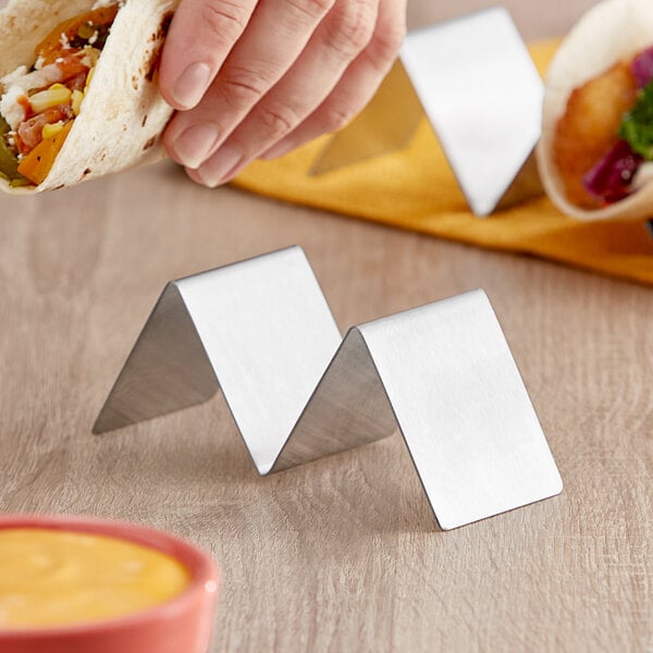 A stainless steel taco holder with two compartments for holding tacos upright.