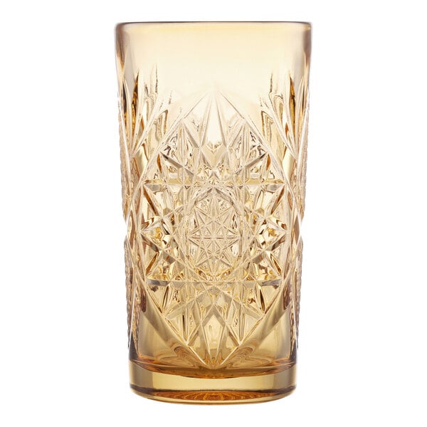 A 16 oz. topaz-colored cooler glass with an intricate cut-glass pattern.