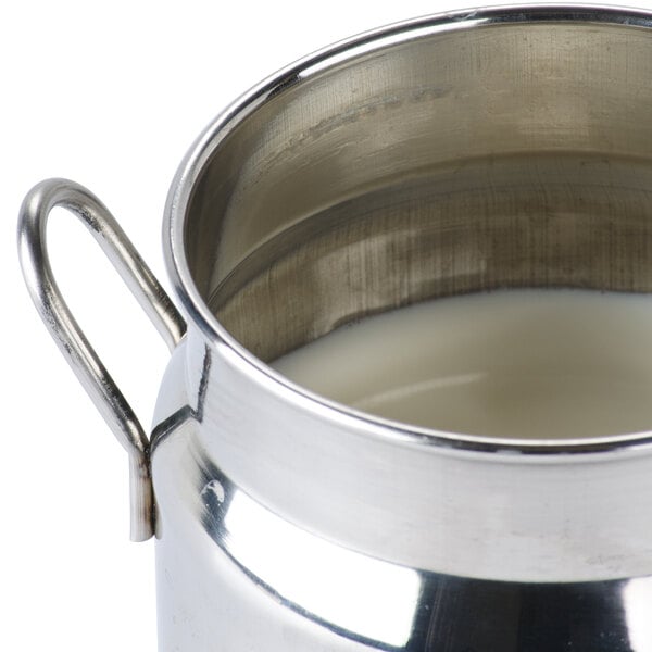 An American Metalcraft stainless steel milk can creamer filled with liquid.