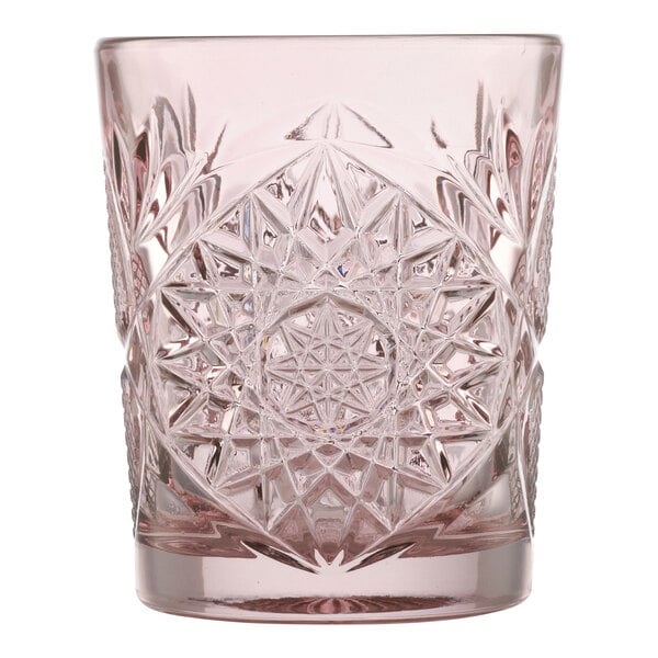A pink cut-glass tumbler with an intricate geometric pattern.