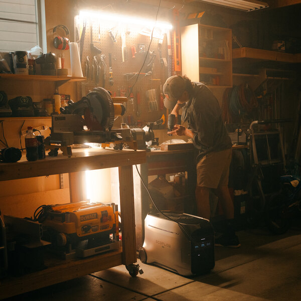 A large EcoFlow DELTA Pro 3 lithium-ion portable power station placed on the floor in a workshop setting.