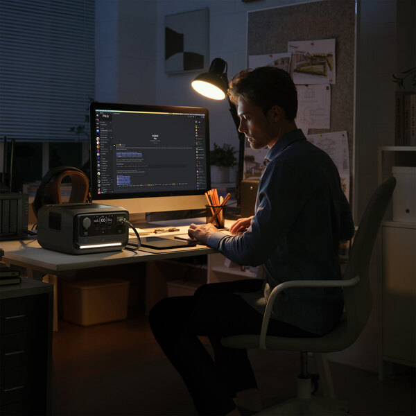 A EcoFlow RIVER 3 Plus portable power station placed on a desk in a home office setting.