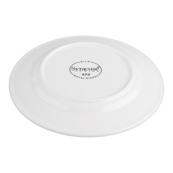 A white porcelain plate shown upside down, displaying a circular maker's mark with text in the center.