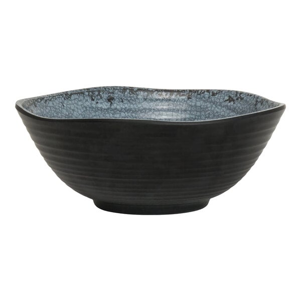 A small round slate-colored melamine bowl with a textured blue interior.