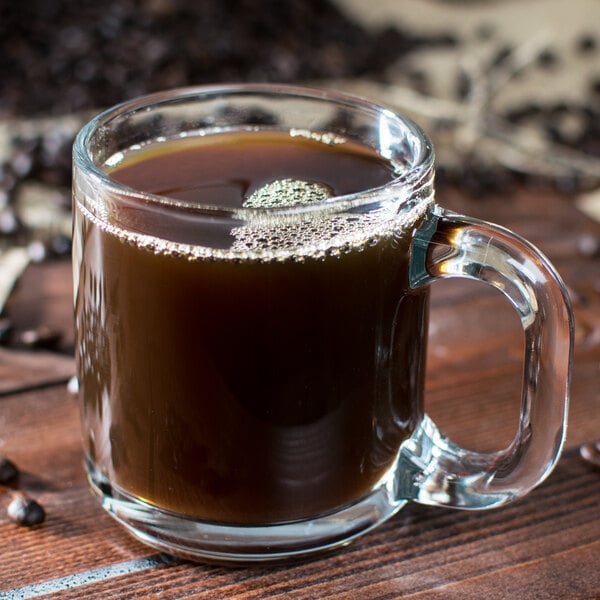 A clear glass mug filled with black coffee, holding 10 ounces.