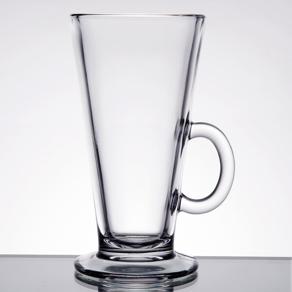 A clear glass coffee mug with a handle and a flared top.